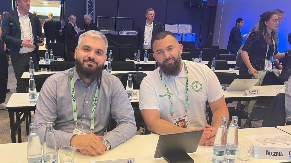 A photo of Karim Kerbouche and Nassim Boulakdem sitting at the Algeria desk at the IIHF Annual Congress